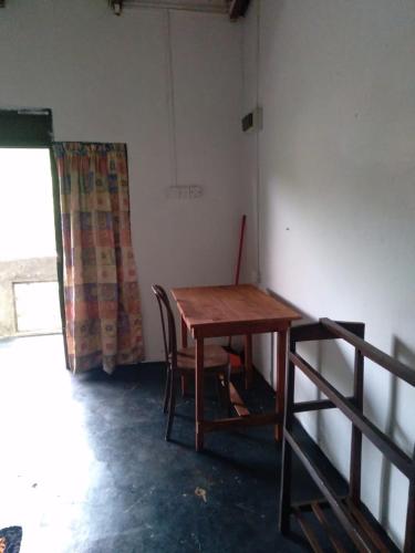 - une table en bois et une chaise dans la chambre dans l'établissement SENN Homestay, à Polonnâruvâ