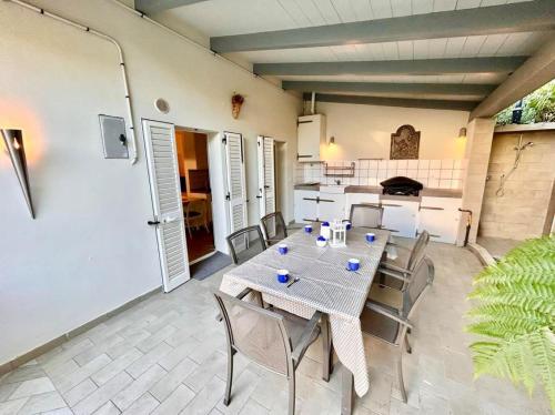 Il dispose d'une cuisine et d'une terrasse avec une table et des chaises. dans l'établissement VILLA MATHILDE deliziosa villetta con spiaggia inclusa, à Numana
