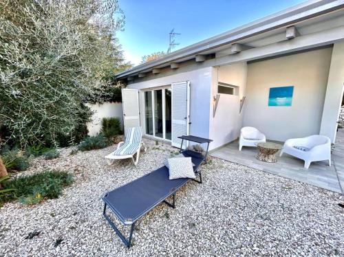 a backyard with a table and chairs and a house at Villa Mathilde, deliziosa villetta con spiaggia inclusa in Numana