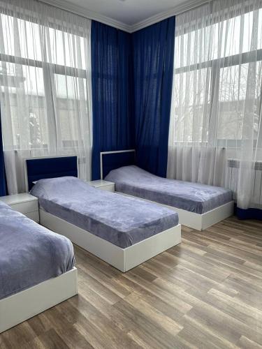 3 łóżka w pokoju z niebieskimi ścianami i oknami w obiekcie Villa in Dzoraghbyur w Erywaniu