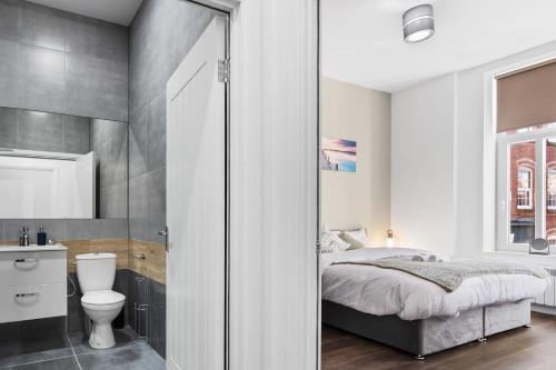 Leicester Luxury Apartments - Church Gate في ليستر: غرفة نوم بسرير ومرحاض