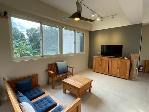 a living room with a couch and a tv at 飲山風民宿 in Jian