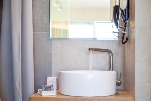 a white sink in a bathroom with a window at Lido Star in Faliraki