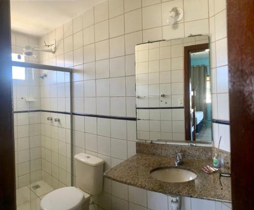 a bathroom with a toilet and a sink and a mirror at Pousada e Restaurante Palomar in Ilhéus