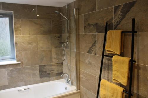 uma casa de banho com um chuveiro e uma banheira em Betula Chalet – coast & country in the Highlands em Nairn