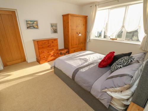 1 dormitorio con 1 cama, vestidor y ventana en Sea Breeze, en Totland