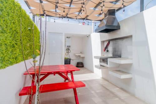 a red bench in a living room with a ceiling at LOFT ULTRA Moderno y Minimalista con 2 Camas KING Size in Durango