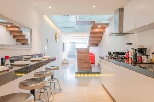a kitchen with stools in the middle of a room at LOFT ULTRA Moderno y Minimalista con 2 Camas KING Size in Durango