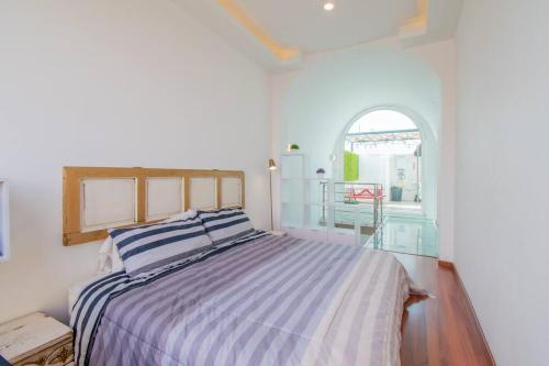 a bedroom with a bed with a blue and white striped blanket at LOFT ULTRA Moderno y Minimalista con 2 Camas KING Size in Durango