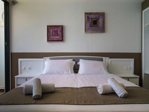 a large bed with two pillows on top of it at Lido Star in Faliraki
