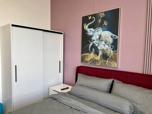a bedroom with a bed and a painting of an elephant at The Classic at Horizon Suites KLIA in Kampong Melot