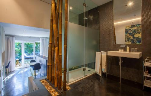 a bathroom with a glass shower and a sink at Casa Vela Boutique House in Cascais