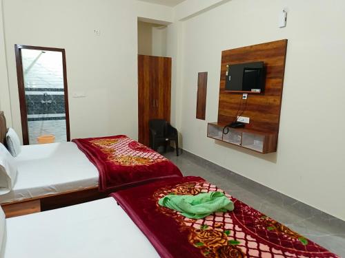 a bedroom with a bed and a tv on a wall at Shri Girraj Residency in Mathura