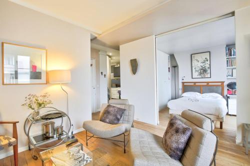une chambre avec un lit et un salon dans l'établissement L'Elégance à la Butte aux Cailles, à Paris