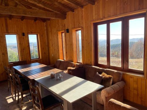 d'une salle à manger avec une table et quelques fenêtres. dans l'établissement Villa Elias, à Zlatograd