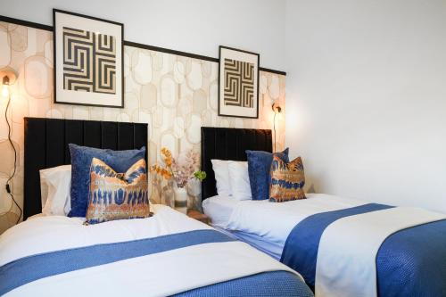 duas camas num quarto com azul e branco em Stunning Abode in London - Private Garden em Londres