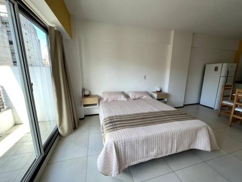 a bedroom with a bed and a large window at Moderno y Luminoso Departamento in Buenos Aires