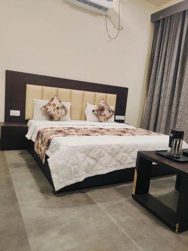 een slaapkamer met een groot bed met kussens en een tafel bij HOTEL KANAL in Kota