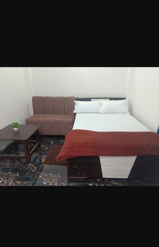 Faizābād的住宿－Blessing Home stay，一张位于配有沙发和桌子的房间的床铺