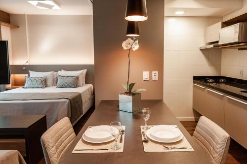a small room with a bed and a table with chairs at Quality Porto Alegre in Porto Alegre