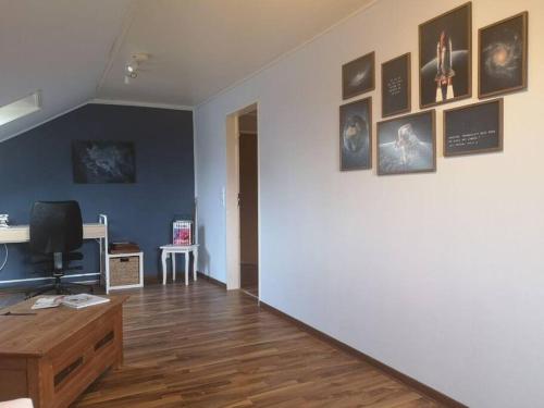 a living room with a white wall with pictures on it at Wohnung mit Blick aufs Blockland in Osterholz-Scharmbeck