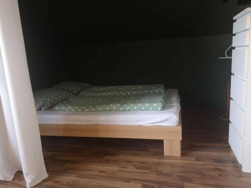 uma pequena cama num quarto com uma parede preta em Wohnung mit Blick aufs Blockland em Osterholz-Scharmbeck