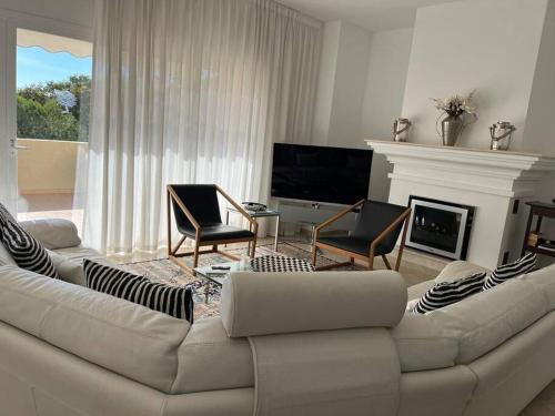 a living room with a couch and a fireplace at R26 Stunning Penthouse Duplex Elviria in Marbella