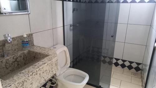 ein Badezimmer mit Toilette, Waschbecken und Dusche in der Unterkunft Casa no Centro de Ibitipoca in Conceição da Ibitipoca
