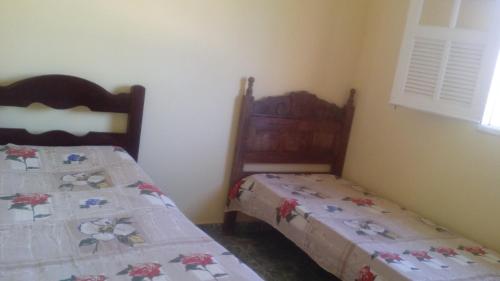 2 Betten in einem kleinen Zimmer mit 2 Betten in der Unterkunft Casa no Centro de Ibitipoca in Conceição da Ibitipoca