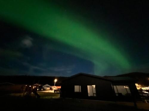 a group of people walking under the aurora borealis at Beautiful Cottage in Hveragerdi in Hveragerði