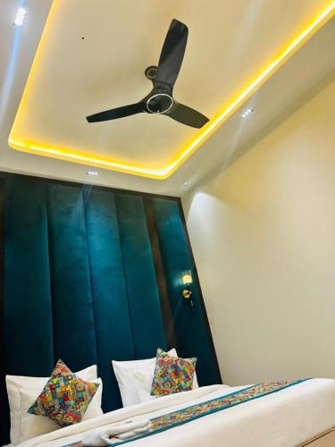 a ceiling fan sitting above a bed with pillows at Taj Dream A Luxury Hotel - Agra in Agra