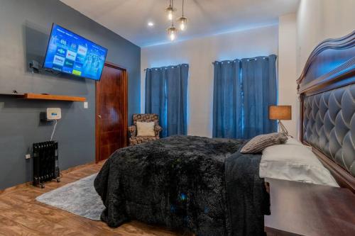 sypialnia z łóżkiem i telewizorem na ścianie w obiekcie Elegante Condo CentroHistórico con Cochera w mieście Durango