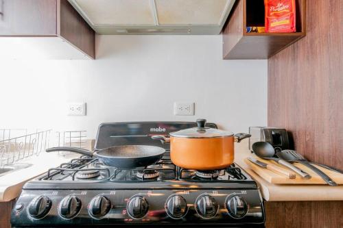 a pots and pans on a stove in a kitchen at Elegante Condo CentroHistórico con Cochera in Durango