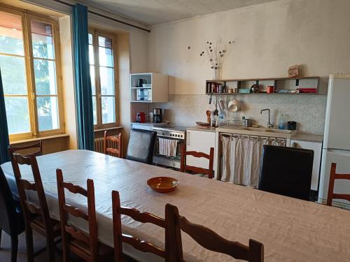 une cuisine avec une table en bois et une salle à manger dans l'établissement Gîte d'étape et de groupe du Clos Saint Roch, à Viviers