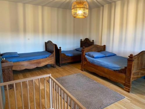 three beds in a room with a chandelier at Villa de 3 chambres avec piscine privee et terrasse amenagee a Tendu in Tendu