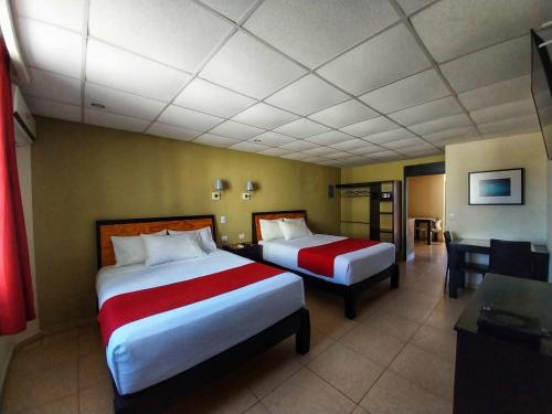 a hotel room with two beds and a desk at Santa Maria del Cabo in San José del Cabo