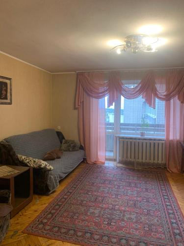 ein Wohnzimmer mit einem Bett und einem großen Fenster in der Unterkunft Апартаменты на пр Гагарина in Dnipro