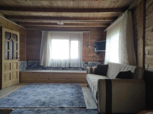 a living room with a couch and a window at Birlik Yaylakent in Sultan Murat Yaylasi