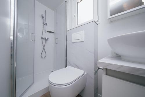a white bathroom with a toilet and a shower at MOBILE HOMES SELCE - Lighthouse in Selce
