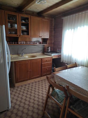 uma cozinha com armários de madeira, uma mesa e um frigorífico em Birlik Yaylakent em Sultan Murat Yaylasi