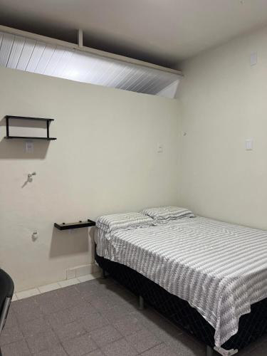 1 dormitorio con 1 cama en una habitación blanca en Excelentes Quartos com banheiros privativos, en Recife