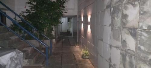 a hallway of a building with a blue stair railing at Excelentes Quartos com banheiros privativos in Recife