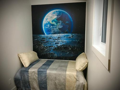 a bed in a room with a picture of the earth at Domaine Gagnon in Saint Sebastien