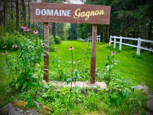 a sign in the middle of a garden with flowers at Domaine Gagnon in Saint Sebastien
