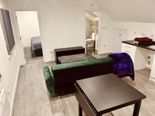 a living room with a green couch and a table at Birmingham Apt-Sleeps 4-Walk to City Centre-Pets in Birmingham