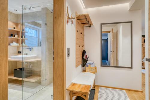 La salle de bains est pourvue d'une douche en verre et d'un banc. dans l'établissement INN Sun Apartment, à Innsbruck