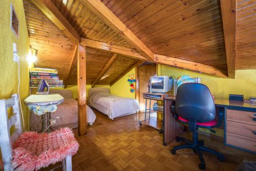 een slaapkamer met een bureau en een bed in een kamer bij Ευχάριστο σαλέ με σοφίτα και τζάκι. in Arachova