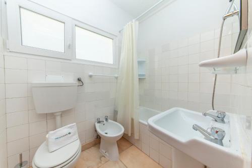 een witte badkamer met een toilet en een wastafel bij B72 - Casa da Calheta Apartment in Praia da Luz in Luz