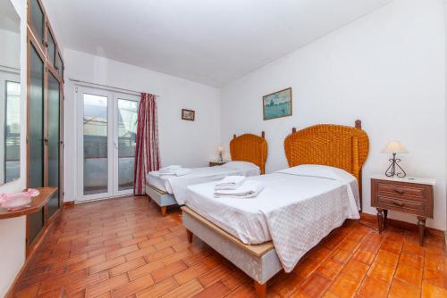 een slaapkamer met 2 bedden, een tafel en een raam bij B72 - Casa da Calheta Apartment in Praia da Luz in Luz