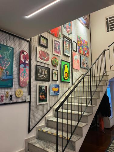 a staircase with a bunch of pictures on the wall at Pousada Bat N Breakfast No Beco do Batman in Sao Paulo